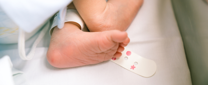 Baby with a medical bracelet on it's leg due to a birth injury