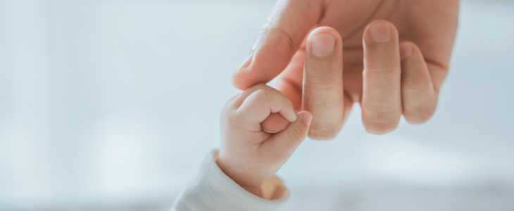 Mother holding her babies hand